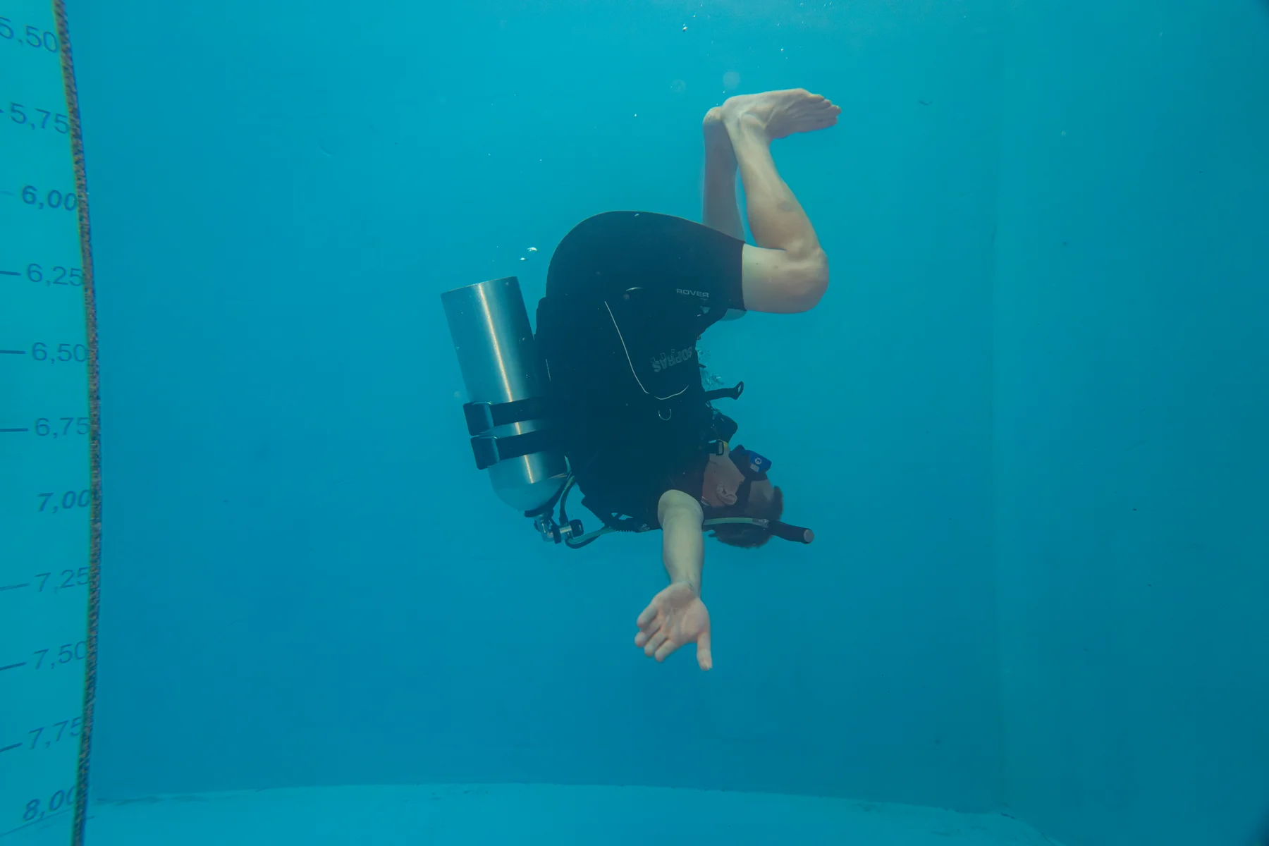 A diver floats in the blue water of the Diving Pit
