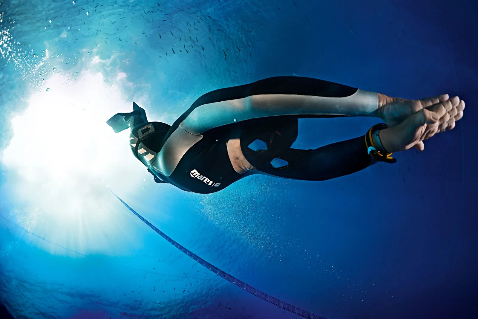 Freediver v pohybu pod prosvětlenou hladinou